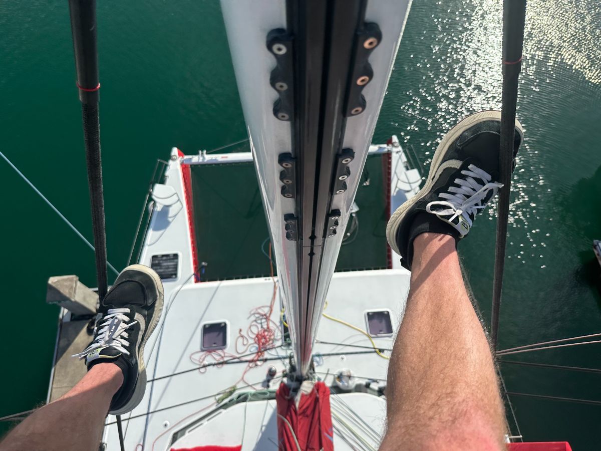 Looking down from the masthead at a catamaran deck and trampolines